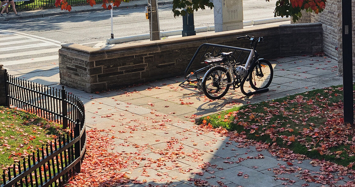 A bike is parked in a bike rack on campus.