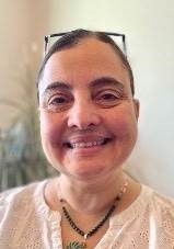 Ana smiling with glasses and a black beads necklace 