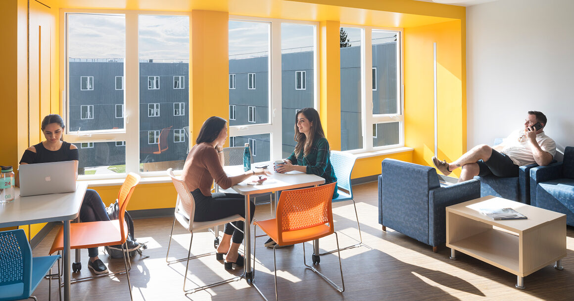 Students work and relax in a lounge in student housing.