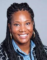 Jamila smiling, wearing a blue shirt and gold hoop earrings