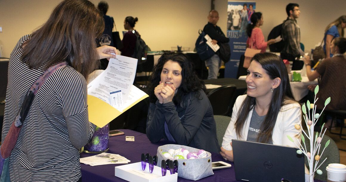 An attendee of the job fair meets with an employer