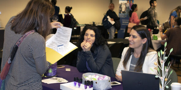 An attendee of the job fair meets with an employer