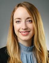 Dr. Rachel smiling, wearing a light blue ruffled blouse and black jacket