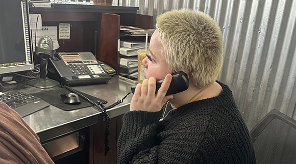 An OLS intern answers the phone at a salon.