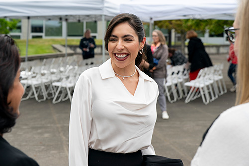 Woman smiles at people she's speaking with.