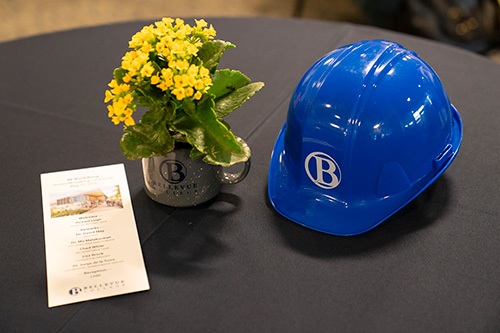 Hard hat with flowers and marketing item on table. 