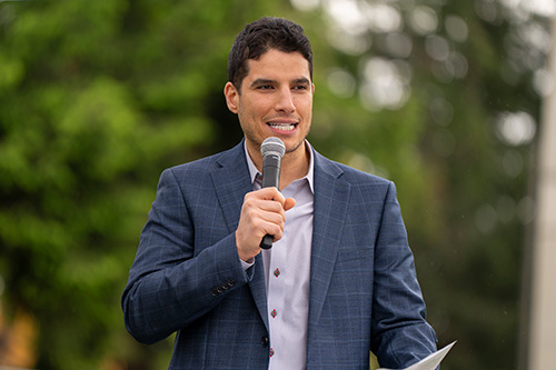 Man holds microphone as he speaks.
