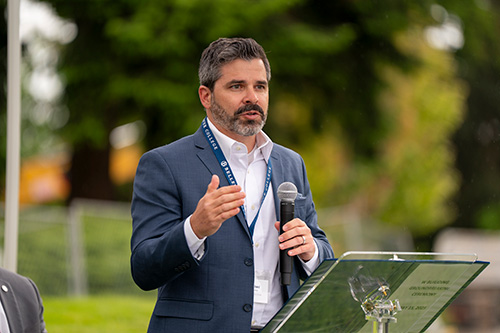 Man holding microphone while speaking.