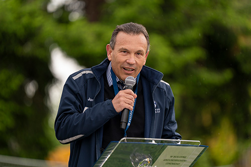 Man speaks into microphone while giving speech.