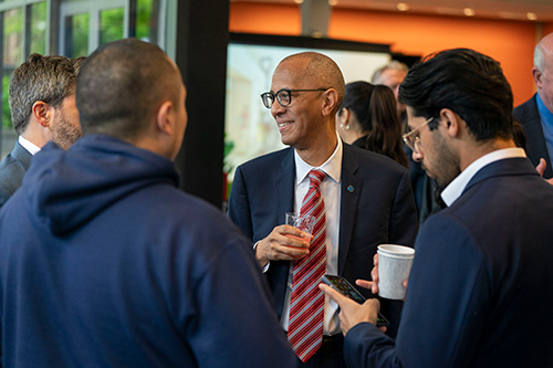 Group of four men chat.