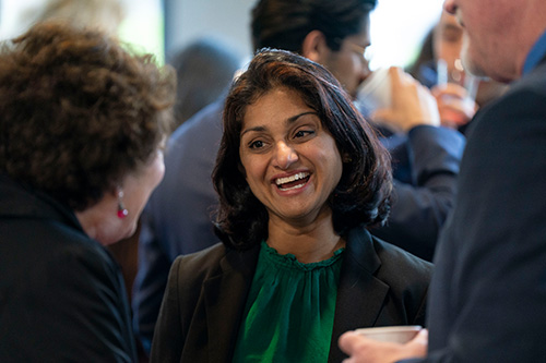 Woman smiles at two people she's talking with.