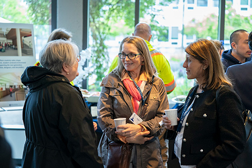 Three women chat. 