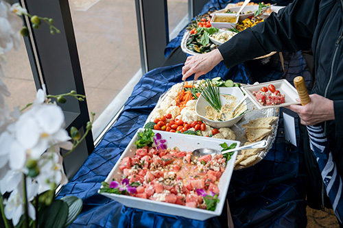 Person serves food from multiple dishes. 