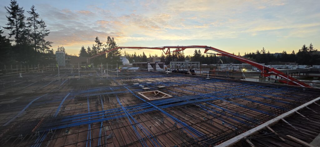 Roof of W Building with red crane and a sunset in the background. 