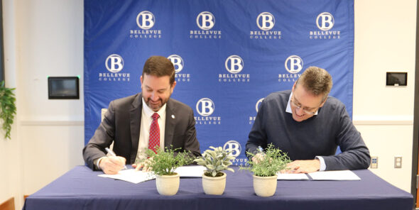 Bellevue College President David May and Western Washington University Provost and Executive Vice President Brad Johnson sign a student guaranteed admission transfer agreement.