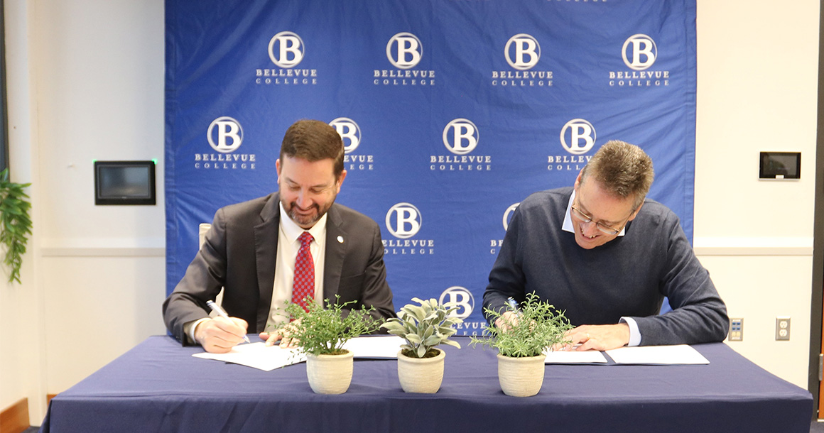 Bellevue College President David May and Western Washington University Provost and Executive Vice President Brad Johnson sign a student guaranteed admission transfer agreement.