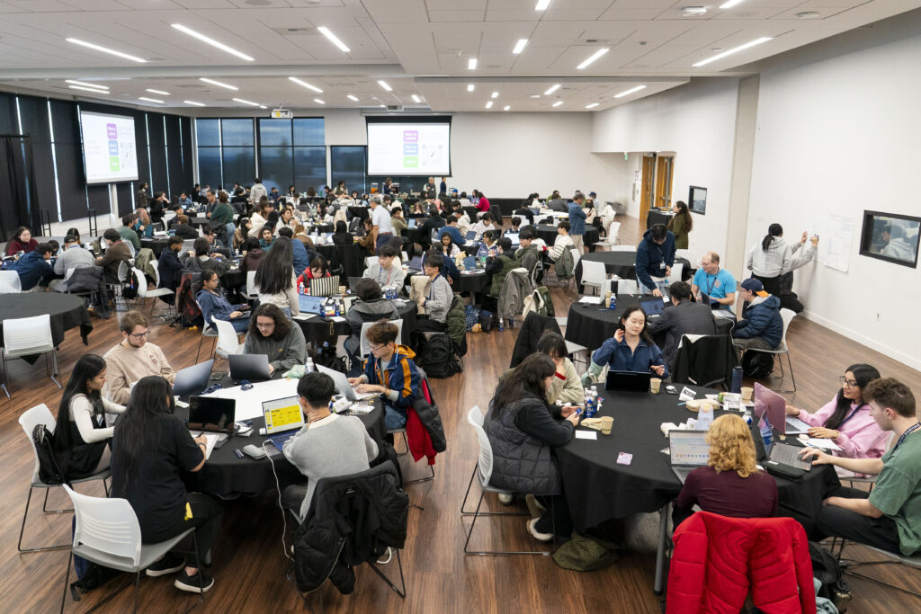 Groups of students at tables in the large ballroom of the U Building on campus.
