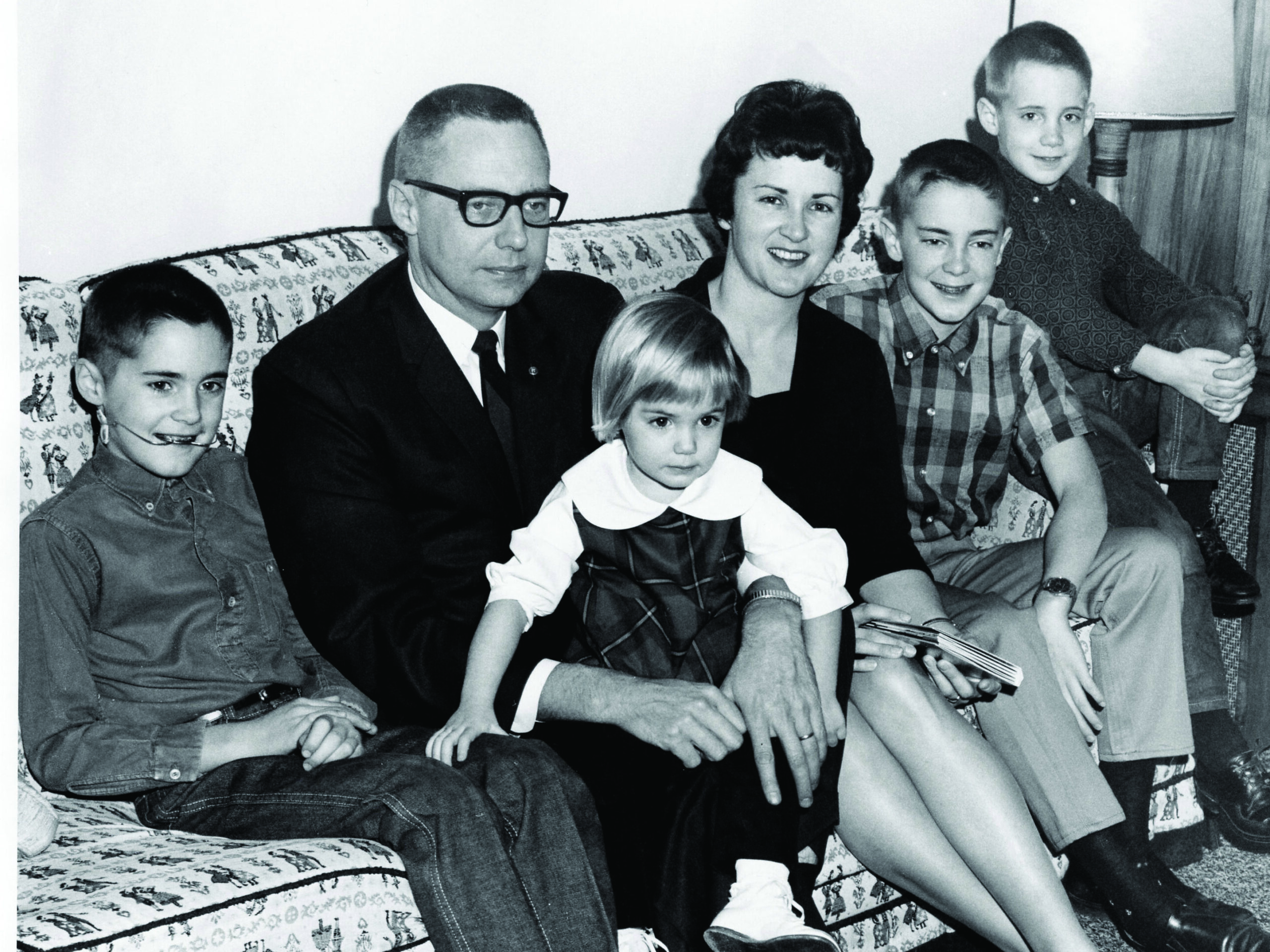 A couple with their four children sitting on a couch.