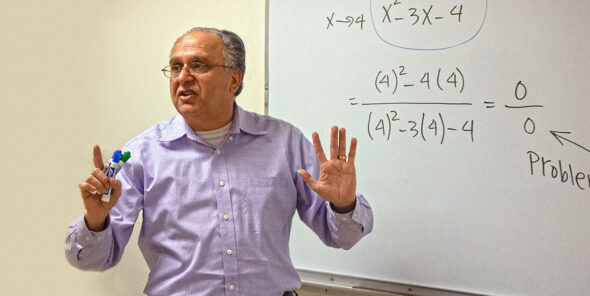 Tony Akhlaghi teaches in front of white board with math on it.