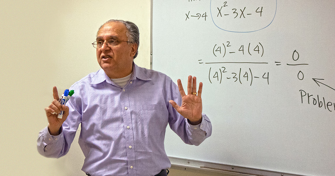 Tony Akhlaghi teaches in front of white board with math on it.