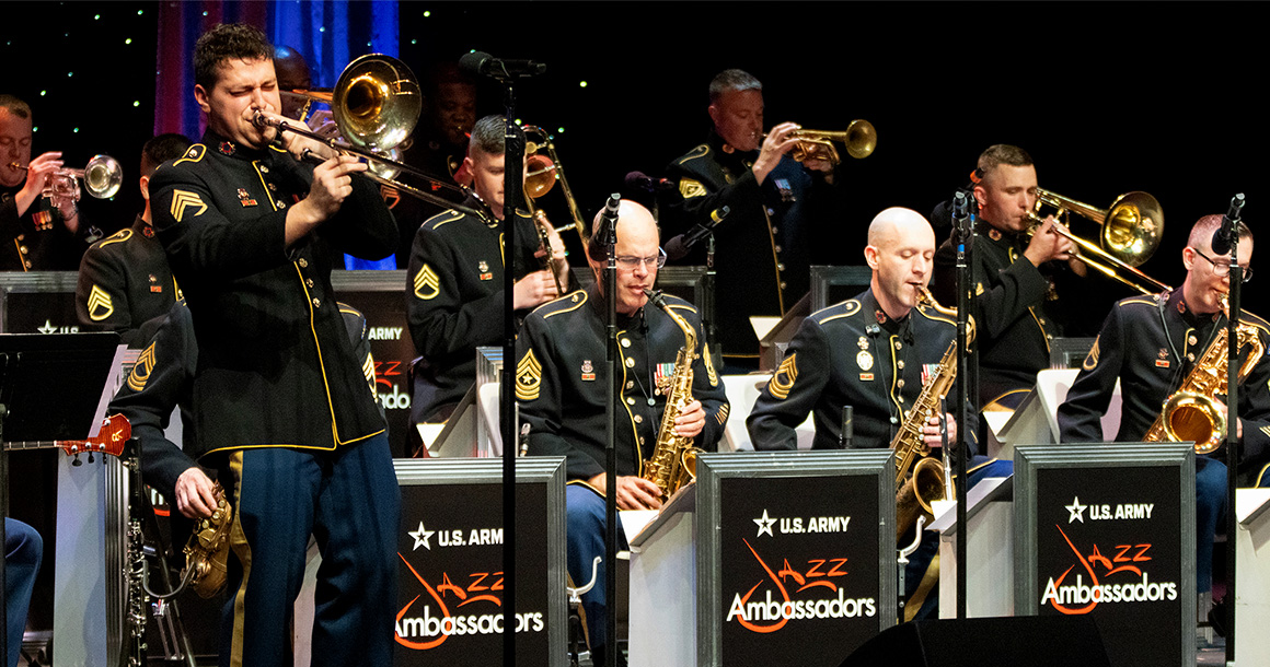 Person plays saxophone in front of other people playing instruments.