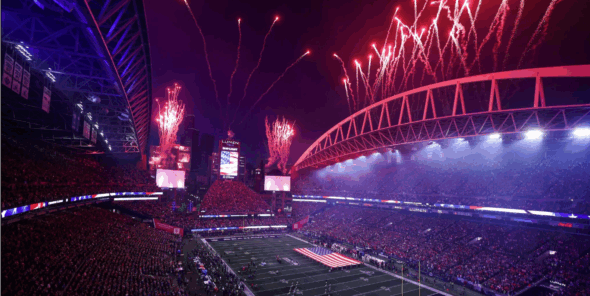 Stadium with fireworks and an American flag on the field.