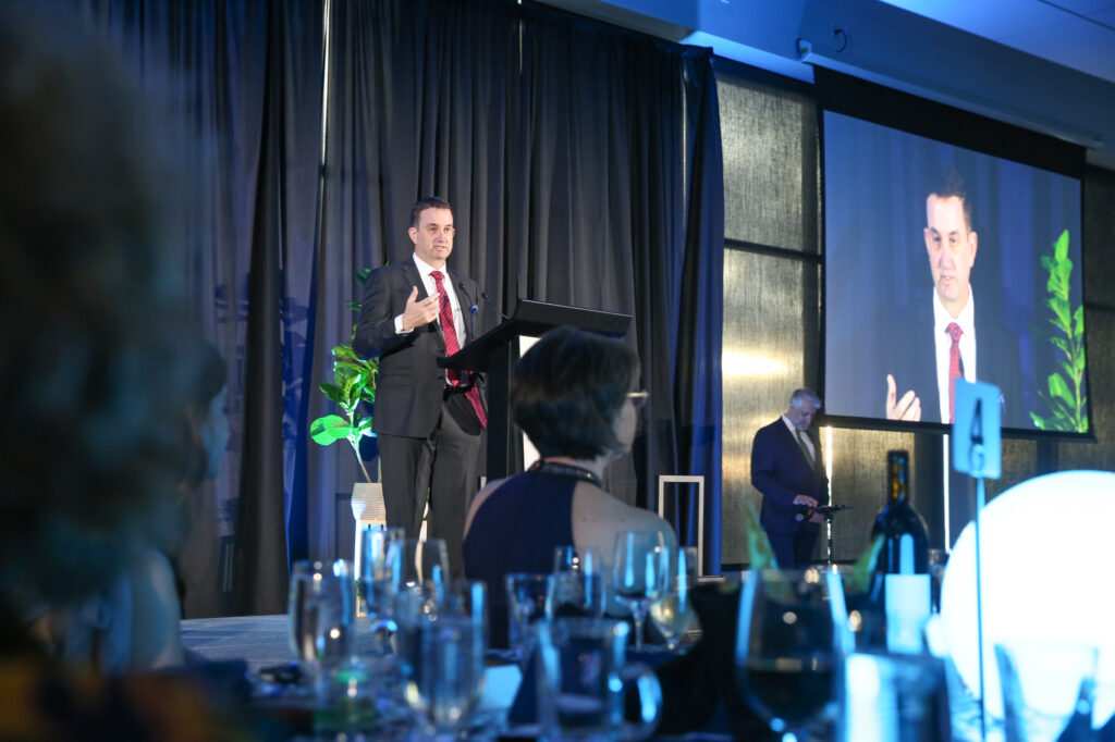 Bellevue College President David May speaks at a podium on stage at the Diamond Jubilee.