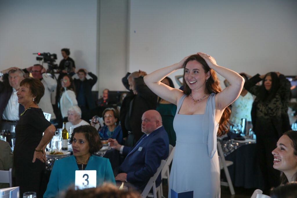 Woman stands in crowd with her hands on her head at the Diamond Jubilee.