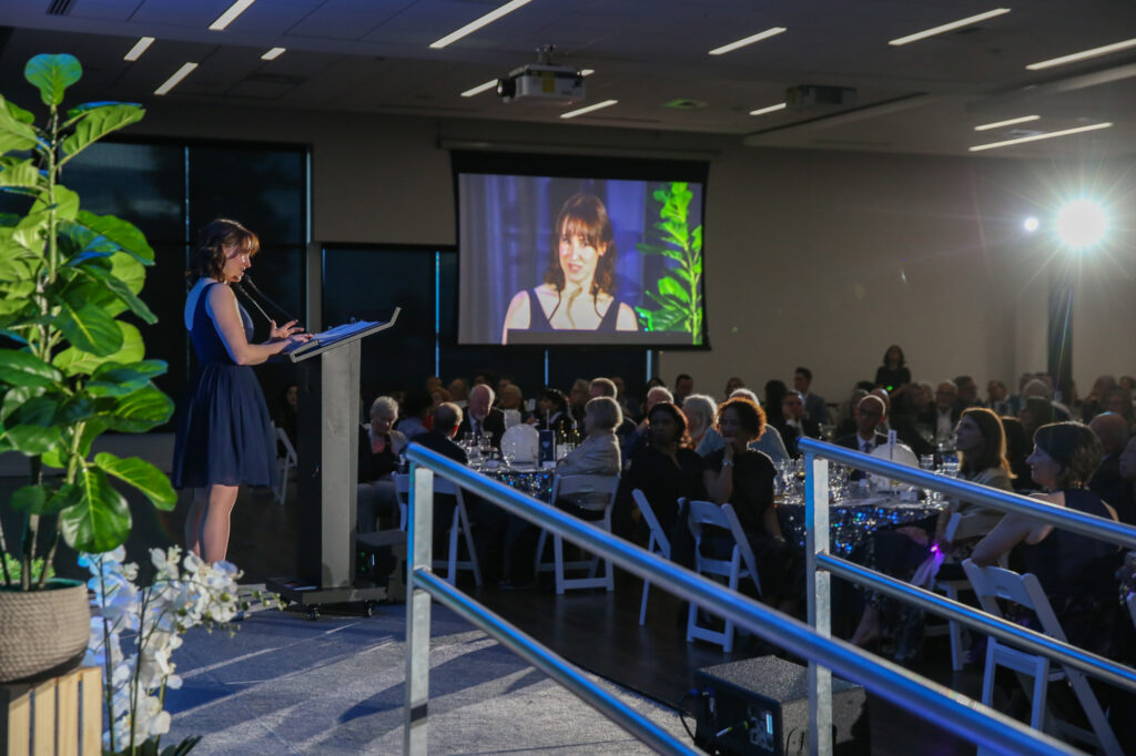 Student speaker Morgan Burke speaks at a podium at the Diamond Jubilee.