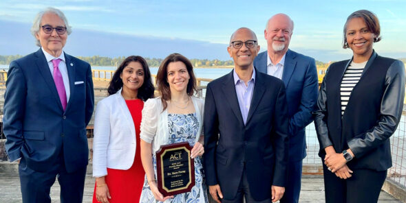 The Bellevue College Board of Trustees stands with faculty member Sara Farag, holding an award.