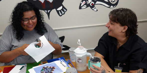 Freedom Education Project Puget Sound staff sit at a table talking and laughing.