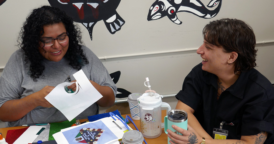 Freedom Education Project Puget Sound staff sit at a table talking and laughing.