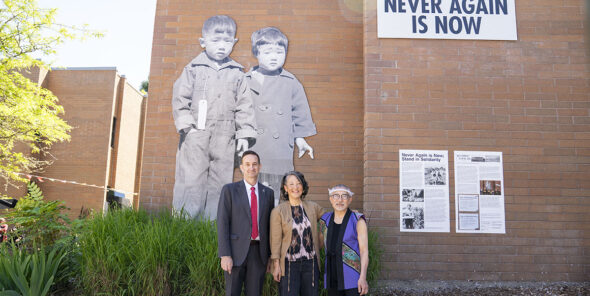 Bellevue College President David May, artist Erin Shigaki, and activist Stan Shikuma stand in front of the Never Again is Now mural on the Bellevue College campus.