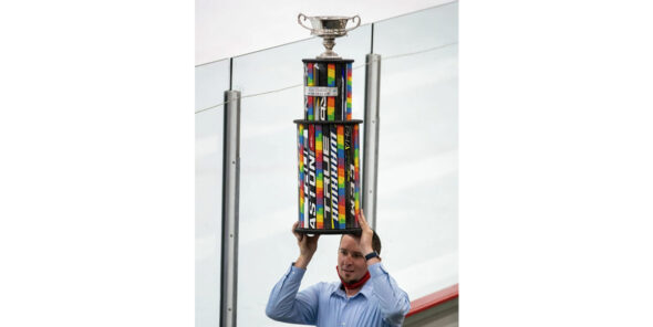 Seattle Pride Hockey Association co-founder Steven Thompson holds the trophy for the Seattle Pride Classic champions over his head.