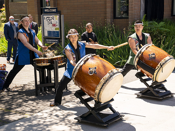 Four Seattle Kokon Taiko drummers play the drums outside.