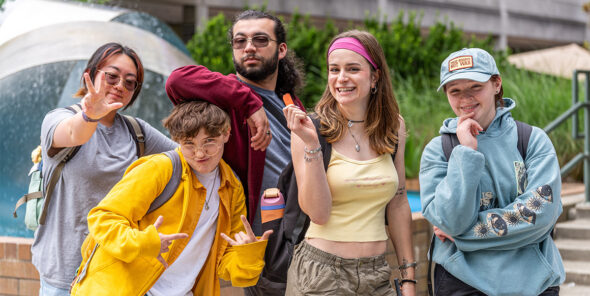 Five students pose for a photo in front of the Bellevue College fountain.