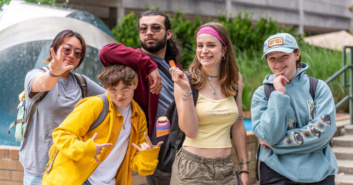 Five students pose for a photo in front of the Bellevue College fountain.