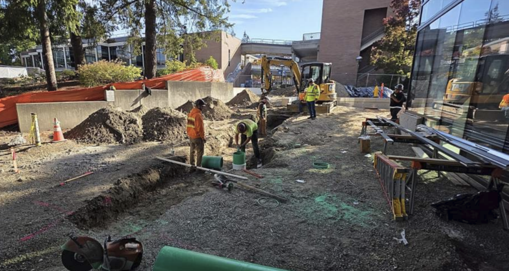 construction workers building a trench next to the W Building