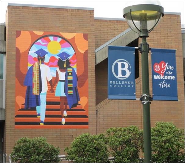 The mural 'Unity' seen in the courtyard north of the Student Union/C building. Two black students clasp hands as they ascend a staircase through a doorway and toward a sunny landscape.