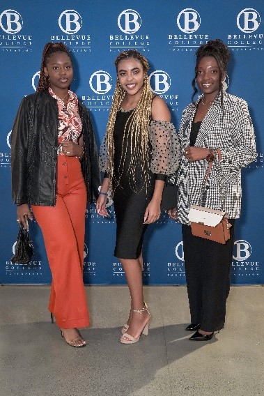 Students and Alumni at the BC Foundation Gala: Patricia Olivia Gelima wears wide leg, apricot pants and a black jacket with a matching bag. Jenny Armadi's black dress has poofy sheer sleeves with black spots. Marita Bwalya is dressed in billowing black pants and a black and white patterned jacket.