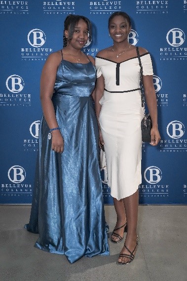 Students and Alumni at the BC Foundation Gala: Christell Kabuya wears a shimmering blue gown and Florida Cishesa wears a white dress with black trim and a matching bag.