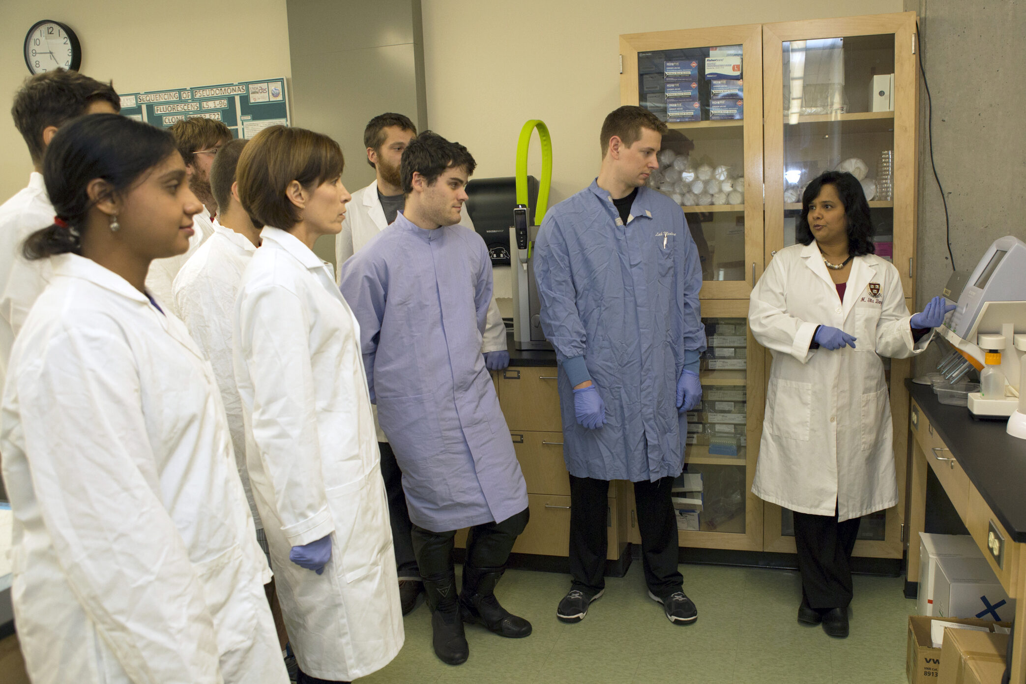 A professor demonstrates equipment in the DNA lab.