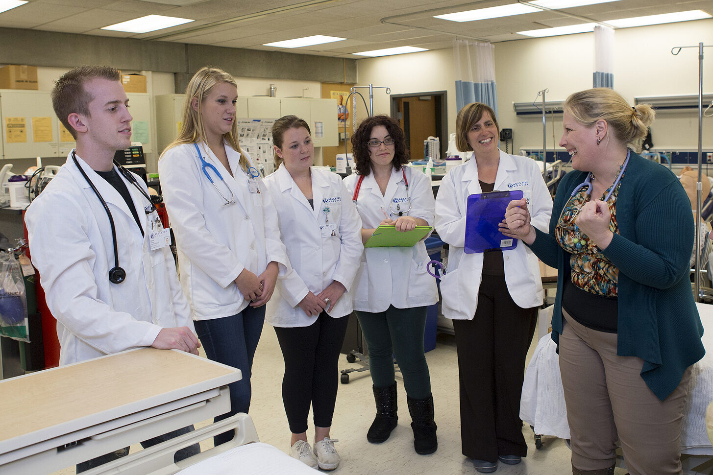 Nursing students discuss with their professor in the Nursing Lab.