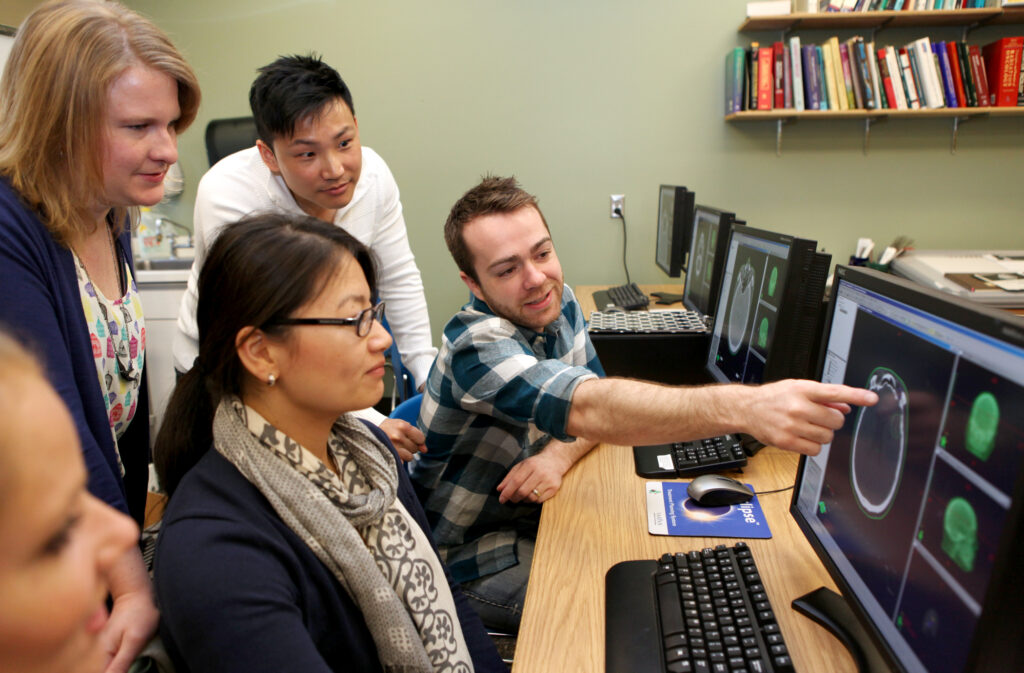 Classmates discuss the image of a skull in the Radiology lab.