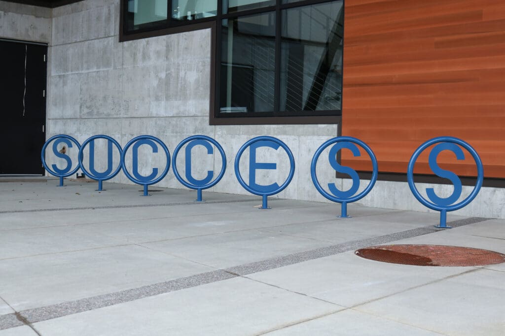 The bike rack by BC's U Building spells out the word "success."