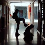 Photo of a student about to kick another student in a school hallway (bullying)