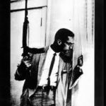 Liberate Our Minds At Any Cost poster with Malcolm X holding a gun