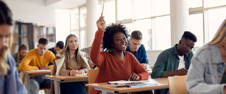 Female student in classroom with her hand raised