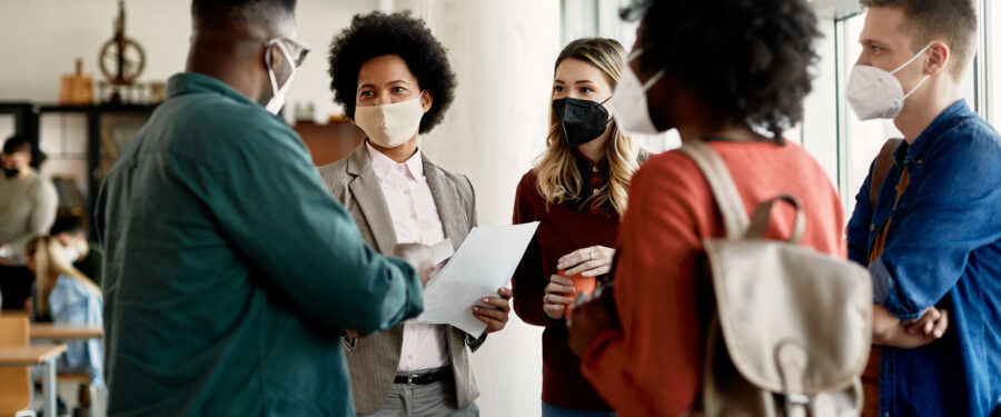 Teacher and students talking, while wearing masks