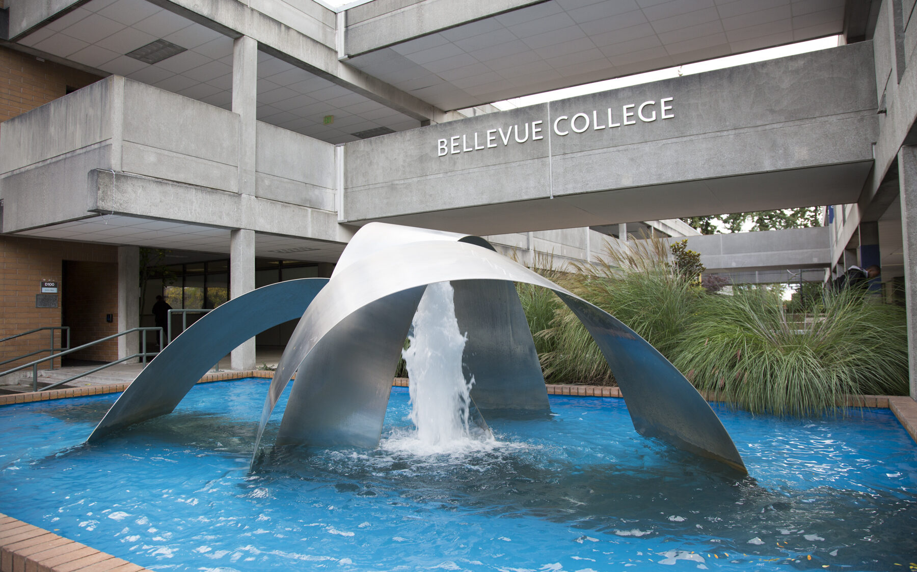 A fountain in front of a campus building with "Bellevue College" in large letters on the exterior